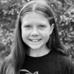 Smiling girl with long hair outdoors.