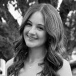 Smiling girl with braces in black and white.