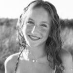 Smiling girl with wavy hair outdoors.